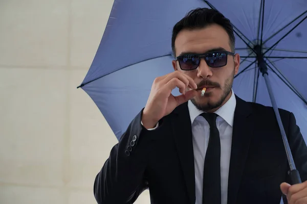 Homme Élégant Dans Des Lunettes Fumant Cigarette Tenant Parapluie Bleu — Photo