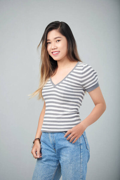 Студийный кадр красивой вьетнамской девушки, улыбающейся в камеру
