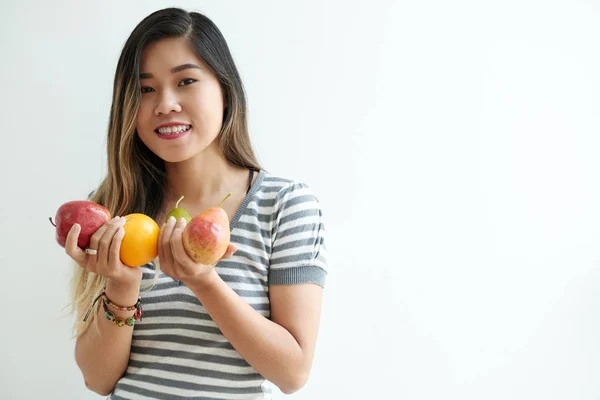 白で隔離熟したフルーツを保持しているアジアの若い女性の笑みを浮かべて — ストック写真