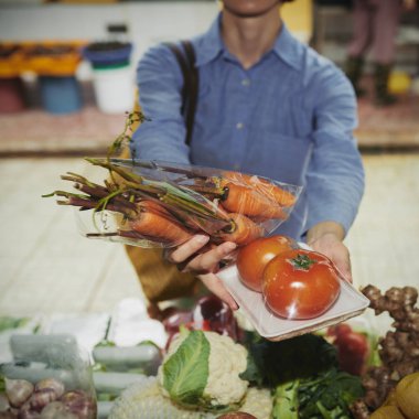 Woman buying tomato and carrots at food market clipart