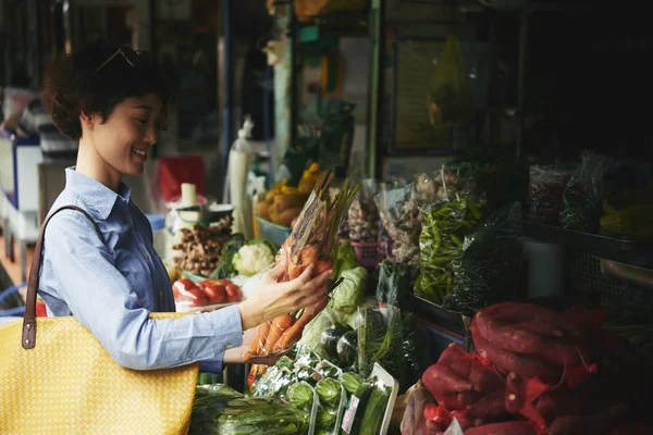 日本年轻女子在市场购买胡萝卜 — 图库照片
