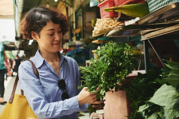 アジアの若い女性食品市場で緑の束を購入 — ストック写真