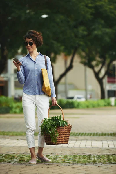 Mulher Sorridente Com Cesta Compras Lendo Mensagem Smartphone — Fotografia de Stock