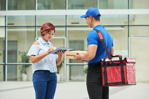 Woman signing receipt for food delivery