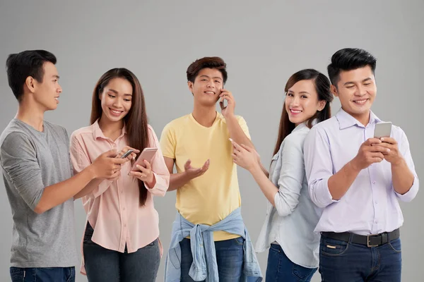 Jóvenes Asiáticos Alegres Utilizando Diferentes Aplicaciones Sus Teléfonos Inteligentes —  Fotos de Stock