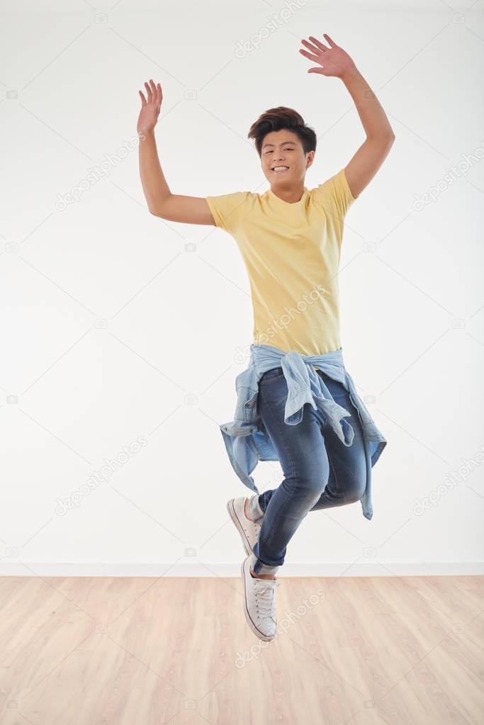 Handsome young Vietnamese man jumping of joy