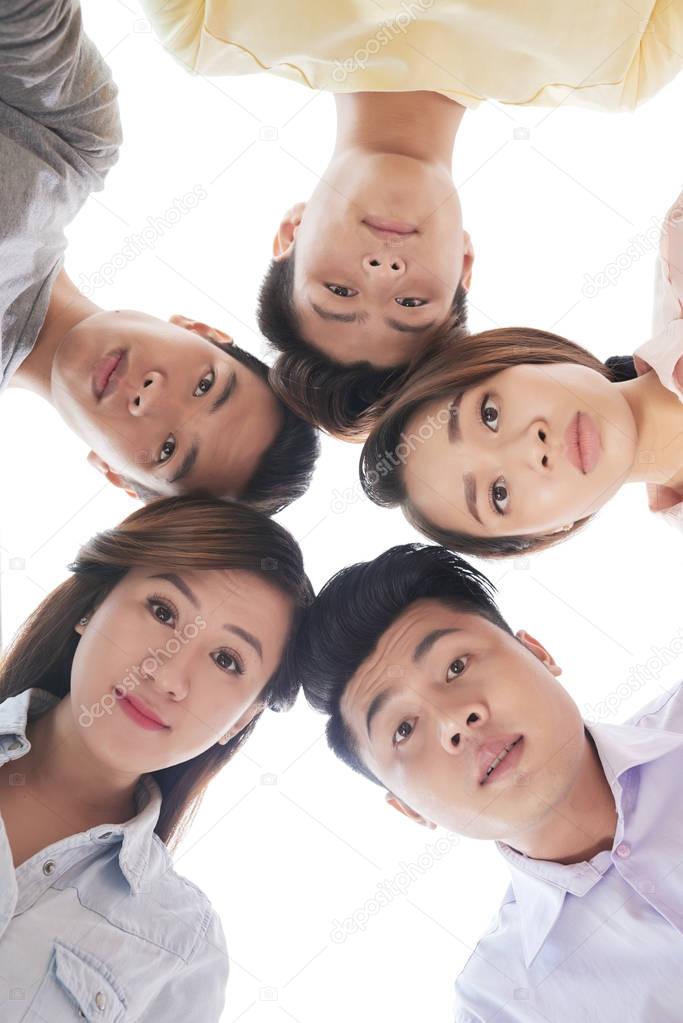 Vietnamese young people looking at camera, view from below