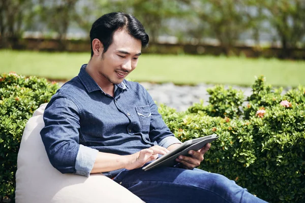 Vietnamita Jovem Sentado Parque Ler Informações Sobre Tablet Computador — Fotografia de Stock