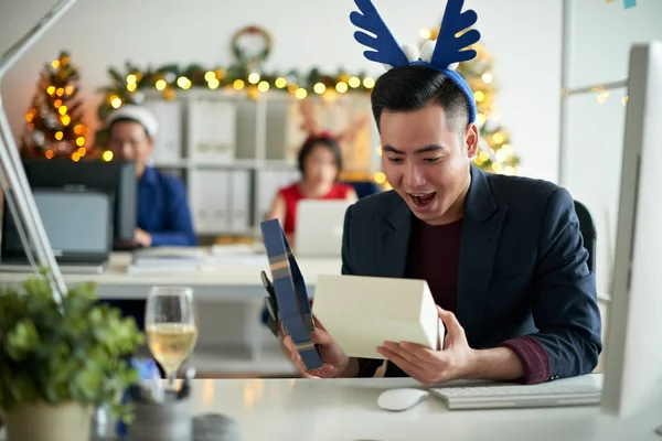 Young Asian businessman excited to see Christmas present