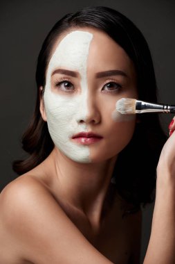 Kil maskesi yüzünün yarısı üzerinde oldukça Asyalı kadın