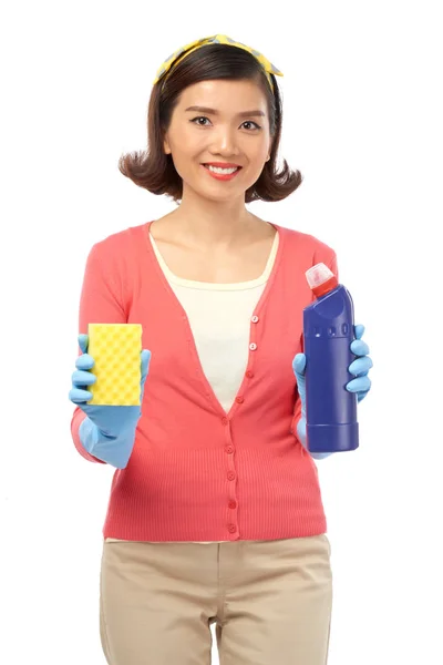 白い背景に分離されたゴム手袋をスポンジや手で洗剤のボトルを押しながら こぼれるような笑みを浮かべてカメラを見て魅力的な若い主婦 — ストック写真