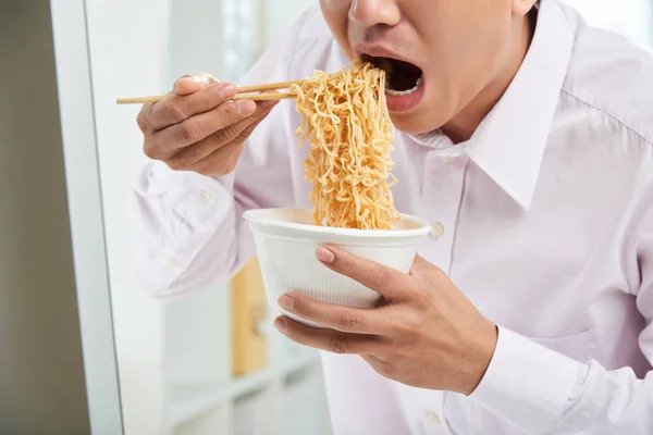 Uomo Seduto Alla Scrivania Dell Ufficio Mangiare Spaghetti Istantanei Con — Foto Stock