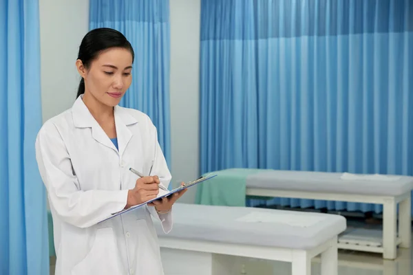 漂亮的越南女医生在文件中记笔记 — 图库照片