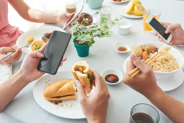 Grupo Pessoas Comendo Verificando Smartphones — Fotografia de Stock