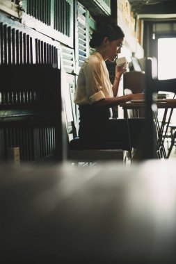 Kahve içme ve yerel kafede sabahları ona e-posta kontrol iş kadını