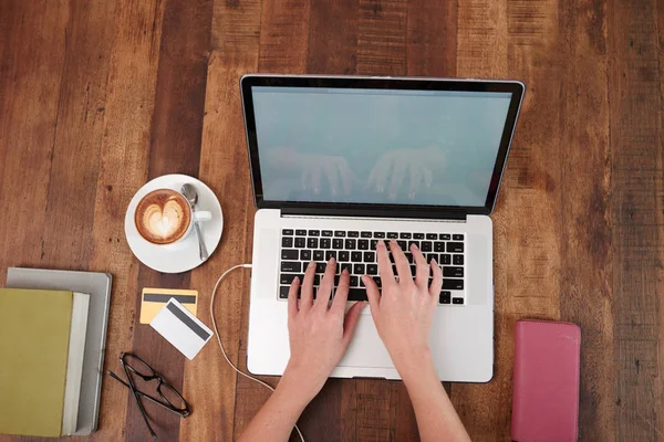 女性双手的顶部视图在咖啡杯咖啡厅的桌上打字键盘 — 图库照片