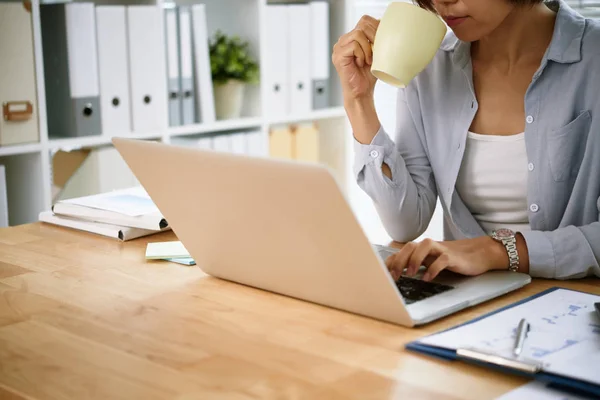 Beskuren Bild Kvinnliga Företagsledare Dricka Kaffe Och Arbetar Bärbar Dator — Stockfoto