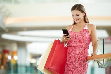Kadın Alışverişkoliğin onun smartphone cep telefonu ile mesaj okuma
