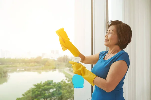 Smiling Mature Asian Woman Wiping Window Her Apartment — Stock Photo, Image