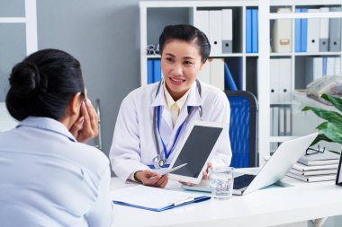 Doktor bilgi dijital tablet üzerinde kadın hastaya gösterilen.