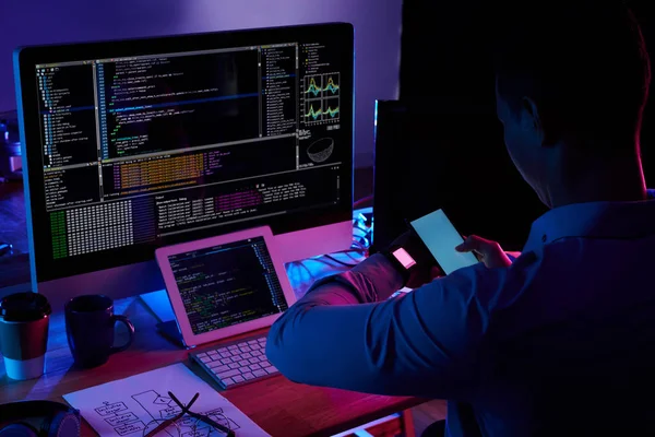 スマート フォンのカメラで彼のスマートウォッチの画面をスキャンするプログラマ — ストック写真
