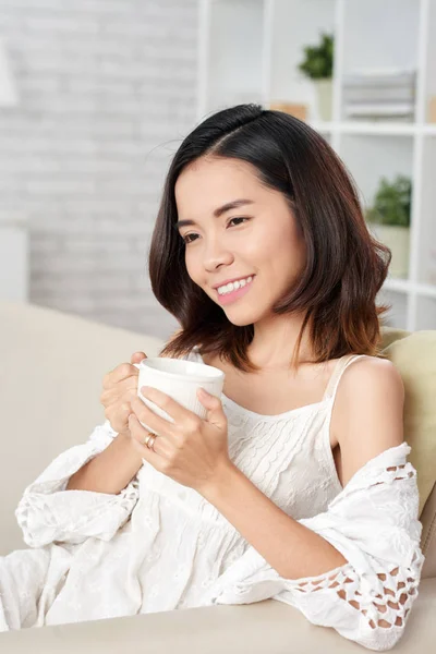 Aantrekkelijke Jonge Aziatische Vrouw Houden Van Thee Beker Zittend Bank — Stockfoto