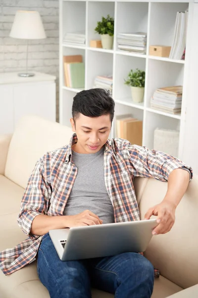 Asiático Hombre Usando Laptop Mientras Sentado Sofá Casa — Foto de Stock