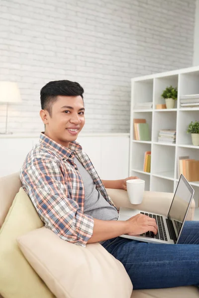 Aziatisch Mens Camera Kijken Met Behulp Van Laptop Zittend Bank — Stockfoto