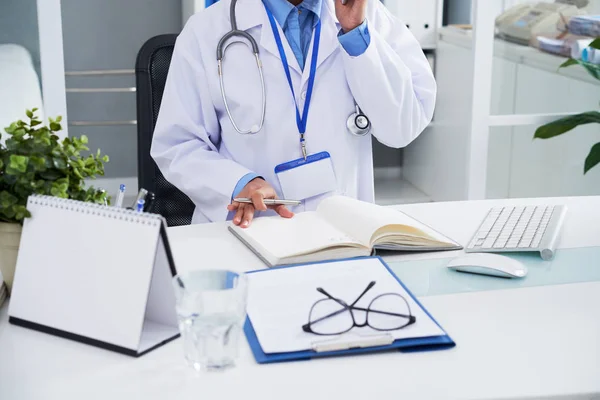 Imagen Recortada Del Médico Llamando Por Teléfono Tomando Notas Libro — Foto de Stock