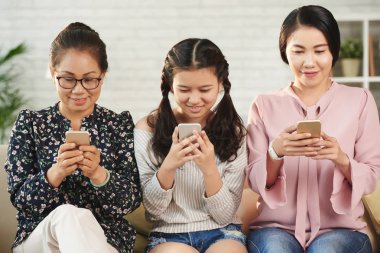Heyecanlı büyükanne, kızı ve torunu akıllı telefonlar üzerinde oyun oynamak
