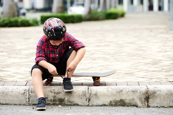 Malý Skateboardista Sedí Chodníku Vázání Boty Před Tréninkem — Stock fotografie