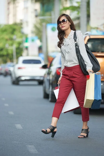 有吸引力的年轻妇女与购物袋横穿路 — 图库照片