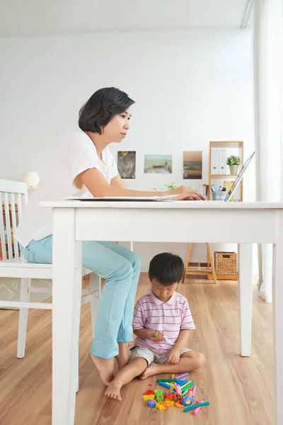 Mujer Vietnamita Trabajando Ordenador Portátil Cuando Hijo Jugando Debajo Mesa — Foto de Stock