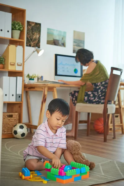 Kleine Jongen Spelen Vloer Terwijl Moeder Achtergrond Werkt — Stockfoto