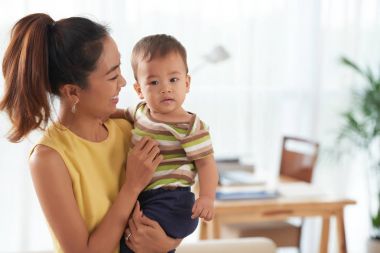 Mutlu genç anne bebek oğlu holding
