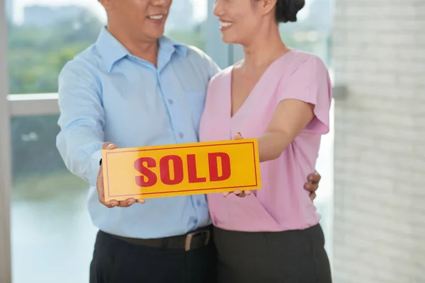Ευτυχισμένο Ζευγάρι Εκμετάλλευση Κάρτα Που Πωλούνται Έχουν Αγοράσει Ένα Σπίτι — Φωτογραφία Αρχείου
