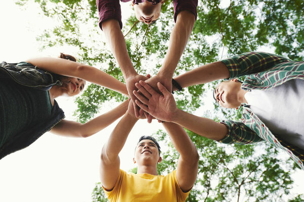 Руки складывают руки, чтобы поддержать друг друга
