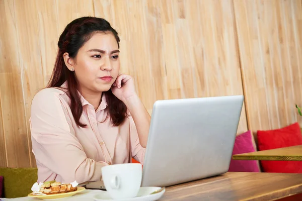 カフェに座っているとき彼女のラップトップの画面の情報を読んでいるベトナムの若いビジネス女性 — ストック写真