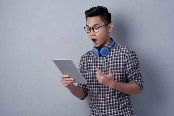Έκπληκτος Νεαρό Άνδρα Στα Γυαλιά Χρησιμοποιώντας Ψηφιακό Tablet Ενώ Στέκεται — Φωτογραφία Αρχείου