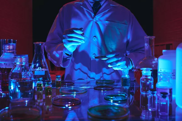 暗い研究室で実験を行う科学者の画像をトリミング — ストック写真