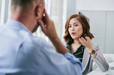 Oldukça Vietnam iş kadını ofiste onun erkek iş arkadaşınız konuşuyor