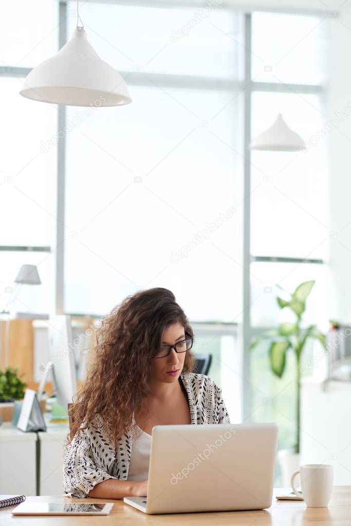 Concentrated financial manager preparing annual accounts with help of modern laptop