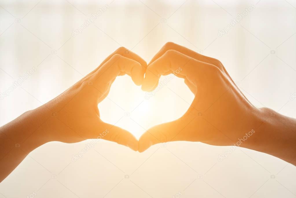 Couple making heart shape with their hands