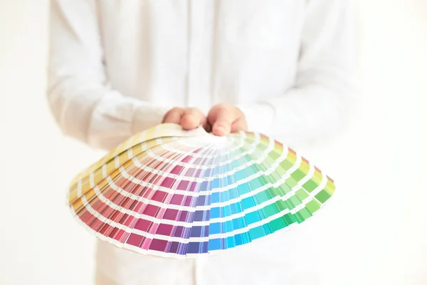 Man holding pallet with paint color samples