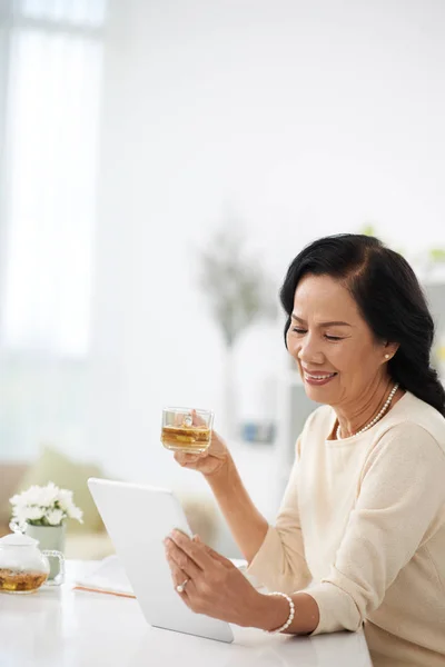 Lächelnde Vietnamesische Alte Frau Trinkt Tee Und Liest Ein Buch — Stockfoto