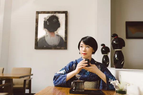 美丽的亚洲妇女在传统的日本餐馆喝茶 — 图库照片