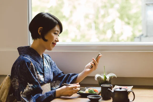 Leende Japansk Kvinna Titta Något Hennes Smartphone När Man Äter — Stockfoto