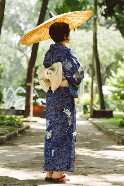 Ιαπωνικά Νεαρή Γυναίκα Στο Μπλε Κιμονό Στέκεται Στον Κήπο Παραδοσιακά — Φωτογραφία Αρχείου