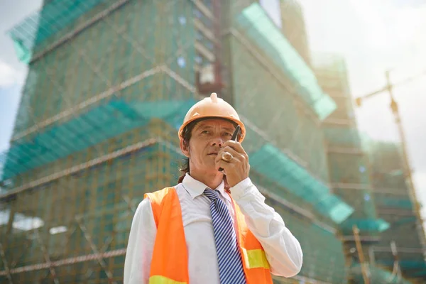 Head engineer communication with workers via walkie-talkie