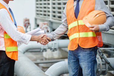 Turuncu yelek tokalaşırken mühendislerince bitki resim kırpılmış